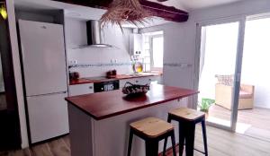 a kitchen with a wooden counter and a large window at El Romeral in Fuenterrobles