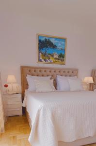 1 dormitorio con 1 cama con colcha blanca en Villa Queen, en Trogir