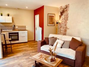 a living room with a couch and a table at Le Cocon Forézien - Emplacement idéal & Charme irrésistible in Feurs