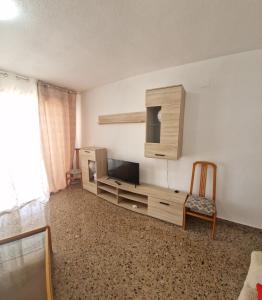 sala de estar con TV y silla en Apartment Svetlana 7 en Alicante