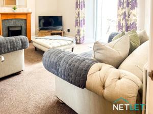 ein Wohnzimmer mit Couch und Kamin in der Unterkunft Hill House in Pembrokeshire