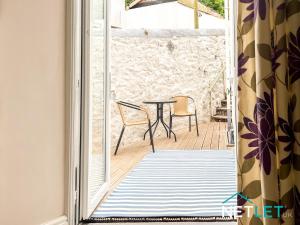 eine offene Tür zu einer Terrasse mit Tisch und Stühlen in der Unterkunft Hill House in Pembrokeshire