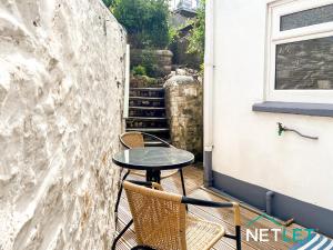 einen Tisch und Stühle auf einem Balkon mit Treppen in der Unterkunft Hill House in Pembrokeshire