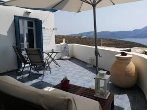 a patio with an umbrella and chairs and a table at Studio Blue Sky in Tripiti