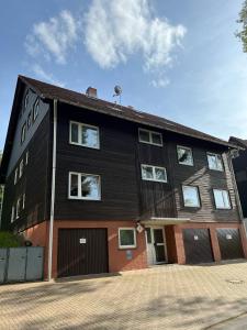 een groot zwart gebouw met een garage bij Ferienwohnung Lia in Altenau