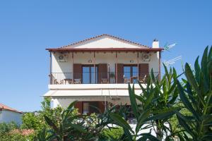 una casa bianca con sedie sul balcone di Bens Apartments-One Bedroom Premium Apartment ad Agia Paraskevi Altre 4 foto