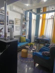 Dea Apartments في باتومي: غرفة معيشة مع أرائك زرقاء وطاولة