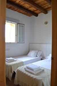 een slaapkamer met 2 bedden en een raam bij Estudio S'ALGA in Sant Francesc Xavier