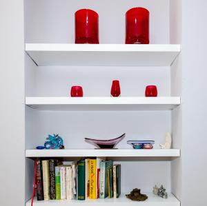 una estantería blanca con libros y gafas rojas en Phoenix Rise Retreat, en Glastonbury