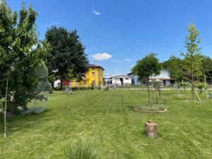 a park with a yellow house and a tree in the grass at Gocce balsamiche in Ravarino