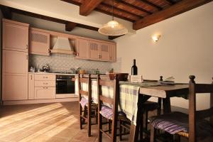 La cocina está equipada con mesa, sillas, mesa y encimera. en Residenza Le Grillaie, en Greve in Chianti