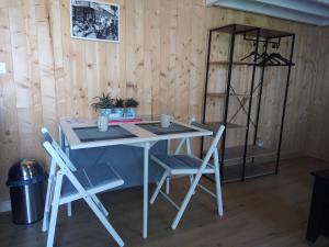 a table and chairs in a room with wooden walls at Les gîtes d'Alex n°2 in Quend