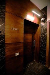 une porte d'ascenseur en bois munie d'un panneau. dans l'établissement The Palm Terrace Penthouse 3BR - Palm Hills - 280 sqm, au Caire