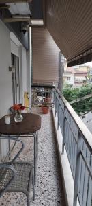a porch with a table and chairs on a balcony at Efchi city center apartment in Katerini