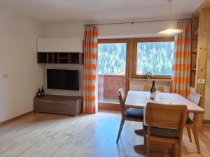 sala de estar con mesa de comedor y ventana grande en Apartments Insam en Santa Cristina in Val Gardena