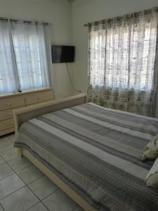 a bedroom with a bed and two windows at Csompó Cozy Small One Bedroom Apartment Beach & River property in St Mary