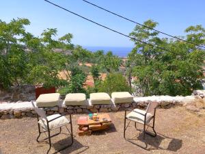 a group of chairs and a table with a view at The Old Barn House in Mesótopos