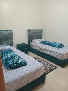 烏季達的住宿－Apart salma，配有两张单人床的客房,设有2个地毯
