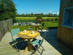 a wooden table and chairs on a patio at Les gîtes d'Alex 1 in Quend