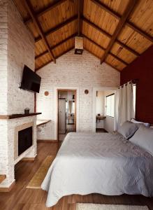 蒙特韦尔迪Vila Ninho da Maritaca的带一张大床和一个壁炉的卧室
