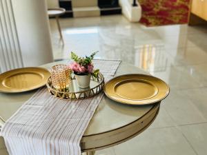 uma mesa com placas de ouro e flores em GoldenWays Motel em Mbabane