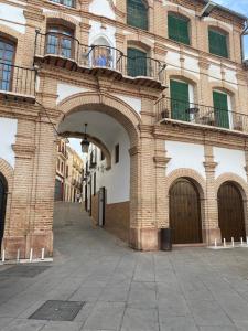un gran edificio de ladrillo con un arco en una calle en Casa Ochavada, en Archidona