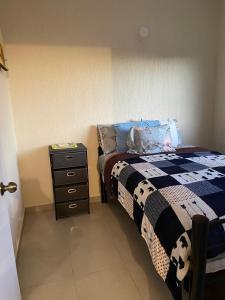 a small bedroom with a bed and a dresser at La Casa Colibrí in San Agustín