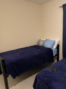 a bedroom with two beds with purple sheets and a pillow at La Casa Colibrí in San Agustín