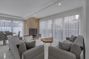 a living room with two couches and a television at NEAR BY THE LAND OF LEGENDs , PRİVATE POOL , VİLLA LARİSA in Belek