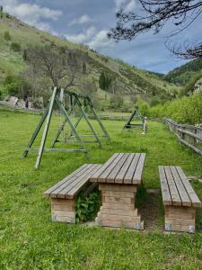 a park with a wooden bench and swings at Seosko domaćinstvo Miko Merdović in Berane