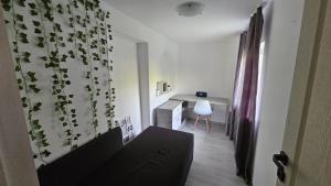 a living room with a couch and a desk at Verebes Cottage with garden in Tuşnad