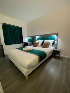 1 dormitorio con 1 cama grande y cortinas verdes en Fasthotel - Soissons Nord en Crouy