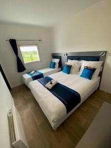 1 dormitorio con 2 camas y ventana en Fasthotel - Soissons Nord en Crouy
