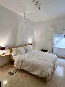 una camera da letto con un grande letto bianco e una finestra di Can Bastida a Cardona