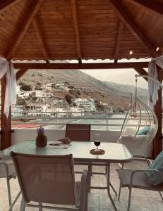 una mesa y sillas en un balcón con vistas en Celestial Loft- By the Sea en Paránimfoi