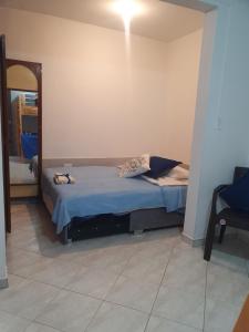 1 dormitorio con 1 cama con sábanas azules y espejo en House Beautiful Horizon P1, en Bogotá