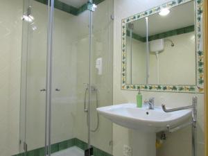 a bathroom with a sink and a shower with a mirror at Casa De Besteiros in Arneiro da Volta