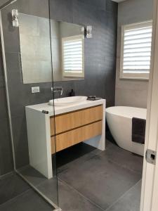 La salle de bains est pourvue d'une baignoire, d'un lavabo et d'une douche. dans l'établissement Hope Island Little Paradise, à Gold Coast