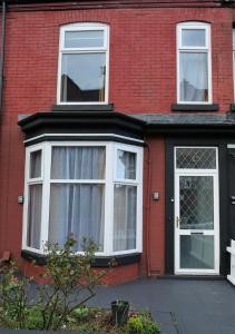 a red brick house with white windows and a door at Comfort Home From Home Bolton Central Hilden St - Sleeps - 10 in Bolton