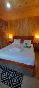 a bedroom with a bed with two towels on it at Cabañas San Valentín in Eldorado +30 photos