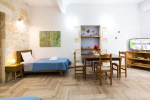 1 dormitorio con cama, mesa y comedor en Eliana's Stone House en Benoudhianá