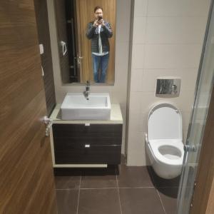 a person taking a picture of a bathroom with a sink and toilet at Le flamand du lac 2 in La Goulette
