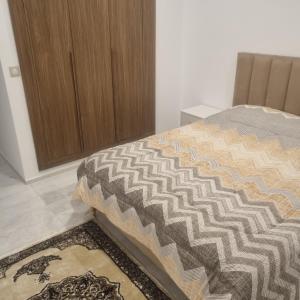 a bedroom with a bed with a brown cabinet at Le flamand du lac 2 in La Goulette +2 photos