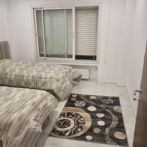 a room with two beds and a rug on the floor at Le flamand du lac 2 in La Goulette