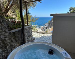 a bath tub with a view of the ocean at o' mar - Amalfi Coast Suite in Praiano