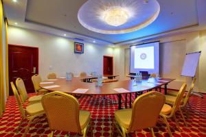 a conference room with a table and chairs and a screen at Hotel Holiday Park in Warsaw