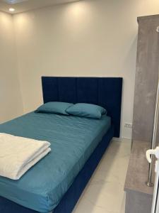 a blue bed with blue pillows in a room at Vip apartmani in Tivat