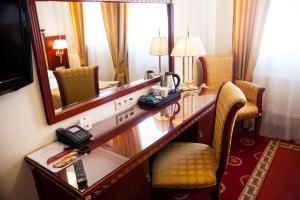 a hotel room with a desk and a mirror at Hotel Holiday Park in Warsaw