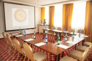 a meeting room with tables and chairs and a screen at Hotel Holiday Park in Warsaw