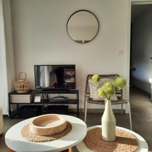 un soggiorno con un tavolo e uno specchio di Green Garden a De Haan